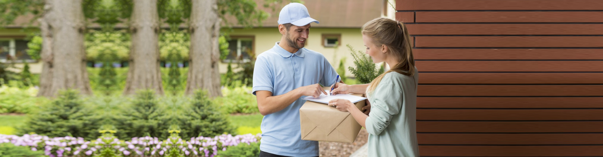 Young courier holding a parcel, women signing a delivery form